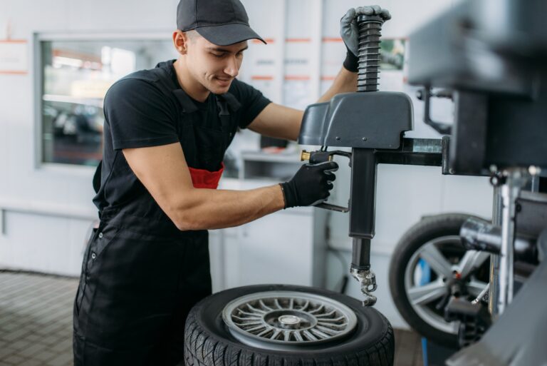 Mechanic fixing wheel on tire fitting machine